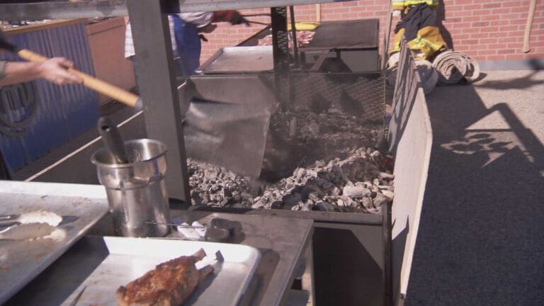 master chef loading charcoal in santa maria grill